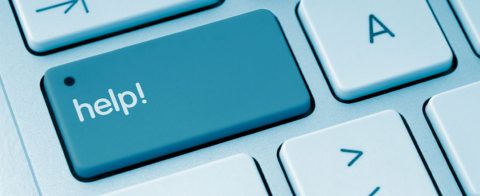 Blauwe toets met "help!" op een toetsenbord, naast witte toetsen.