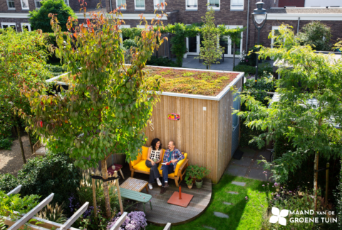 Stel met tuinhuis, dakterras en bomen; een koppel op de bank geniet van de groene tuin.