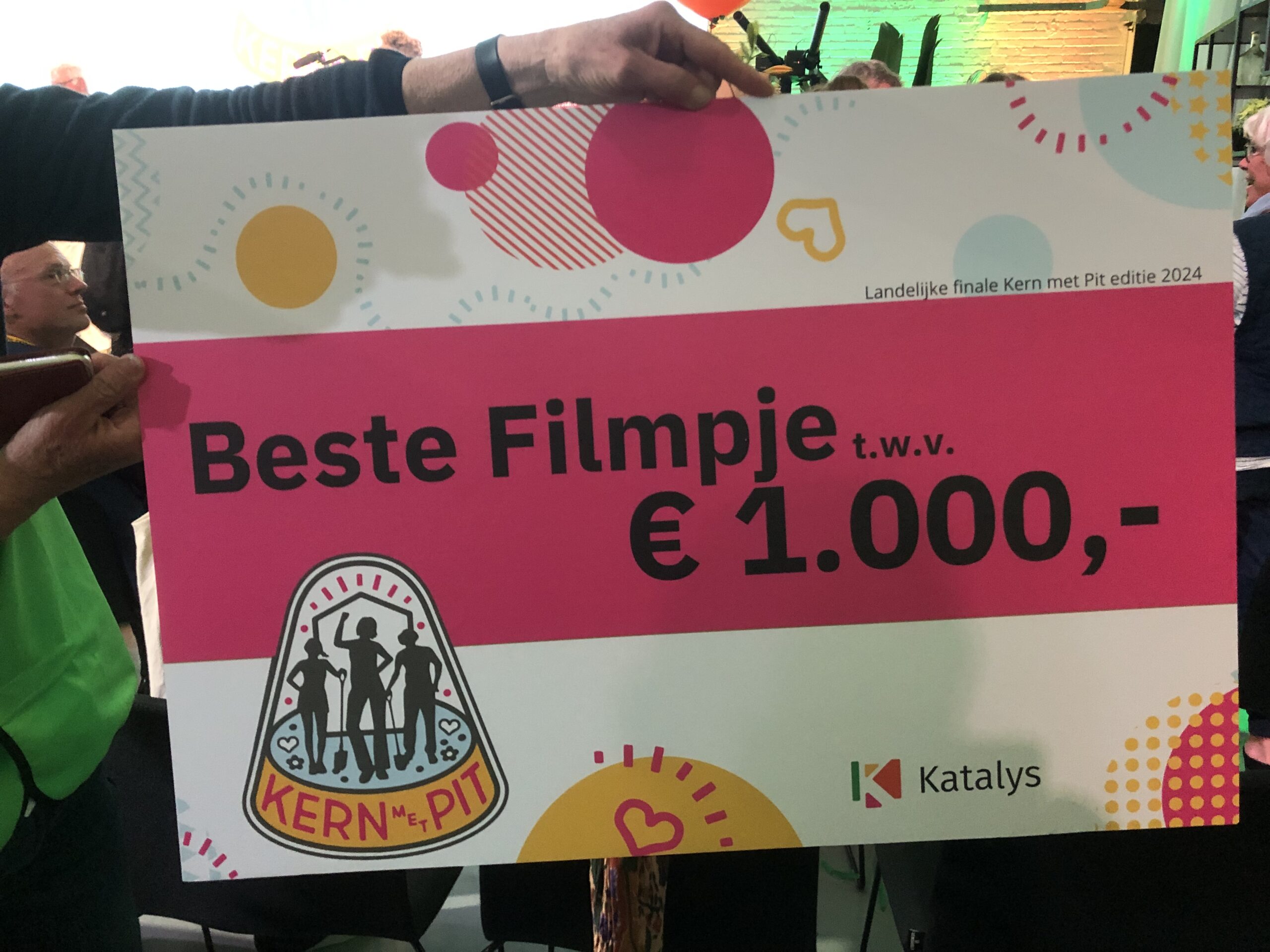 Een bord met de tekst: "Beste Filmpje, t.w.v. € 1.000,-" bij Kern met Pit evenement.