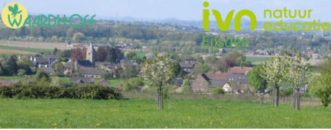 Landschap met groene weide, dorp in de verte, en logo's van Waardhoff en IVN natuur educatie.