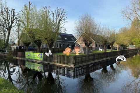 Gebouwen en bomen langs een beek met cartoonkinderen en dieren, bord "De Goudse Hofsteden".