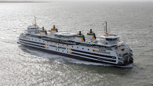 Grote veerboot op zee met meerdere dekken en kleurrijke accenten, vaart naar links.