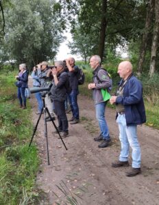 De vogelwerkgroep in actie. Kijkend door een verrekijker en een spatting scope krijgt iedereen de kans om alle vogels in de omgeving te zien