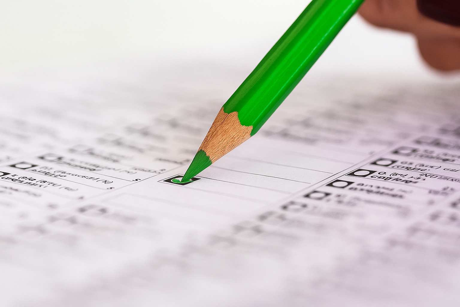 Groen potlood markeert een hokje op een formulier of enquête.