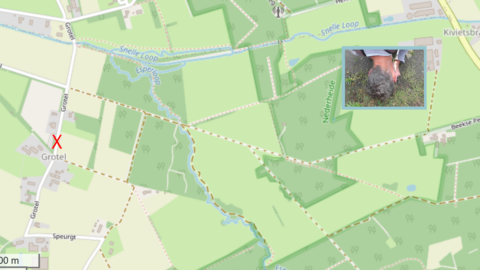 Kaart van Grotel met rode X-markering en inset van persoon met handen in de aarde.