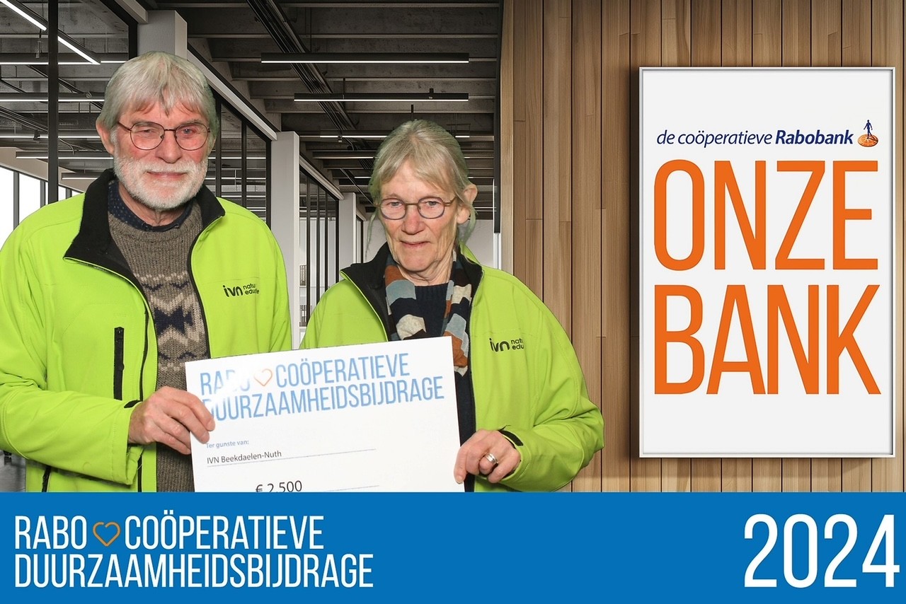 Twee mensen in groene jassen houden een cheque voor duurzaamheid van Rabobank vast.