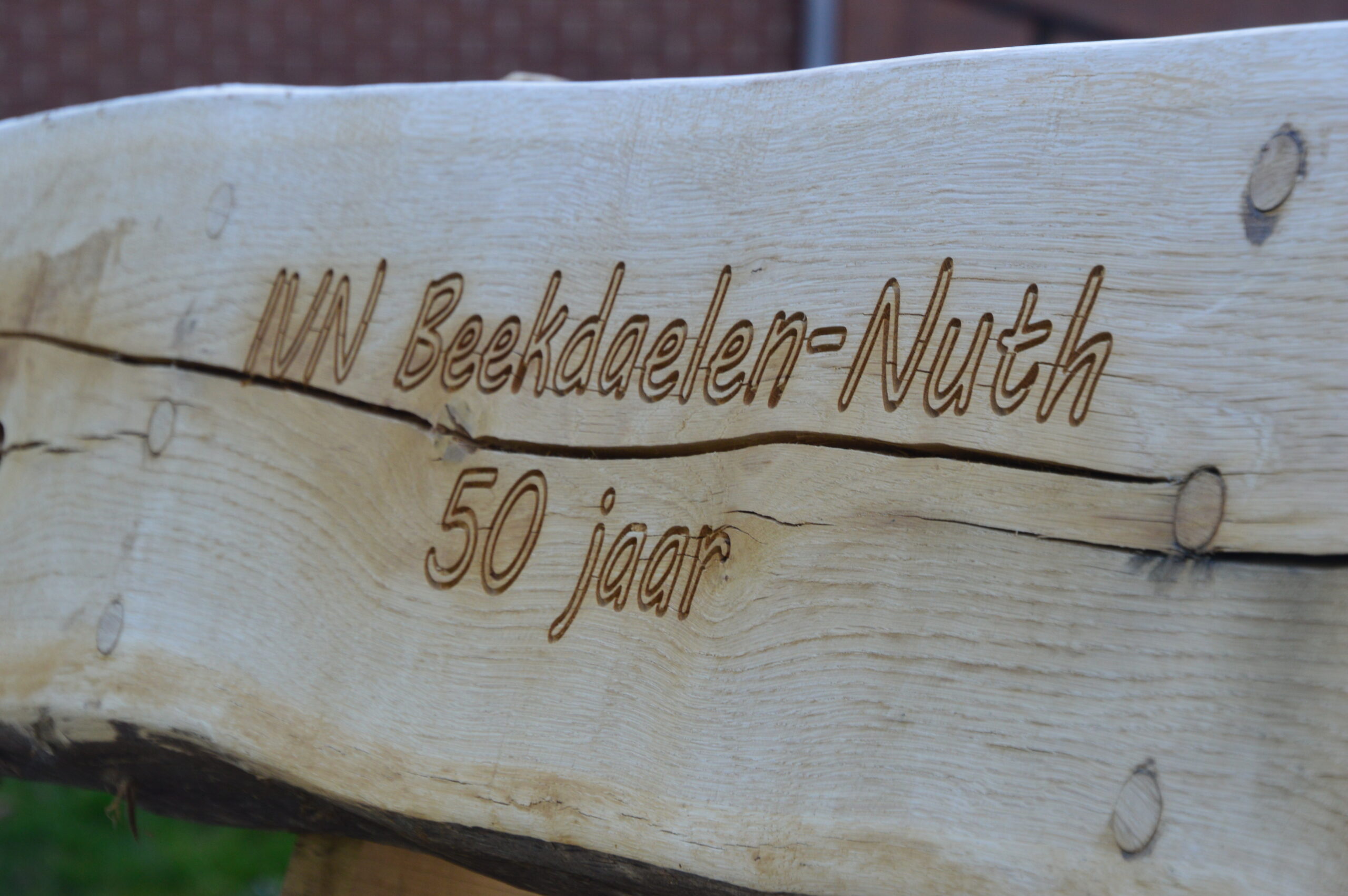 Houten bord met inscriptie: "IVN Beekdaelen-Nuth 50 jaar".