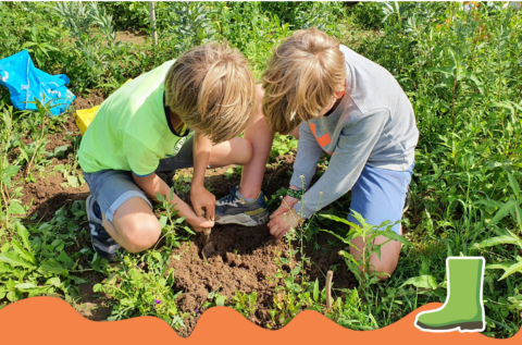 Kinderen werken samen in een tuin, zittend op de grond en plantaardig groen om hen heen.