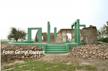 Ruïne met groene structurele accenten en omringende stapels stenen in een weids landschap.