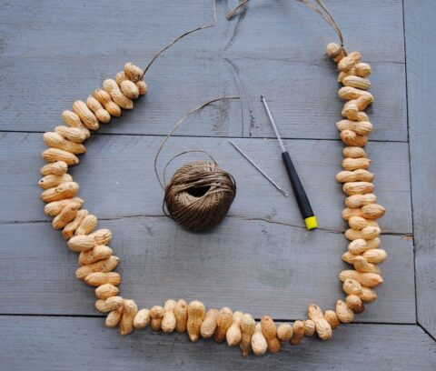 Pindasnoer op tafel met touw, naald en schroevendraaier.