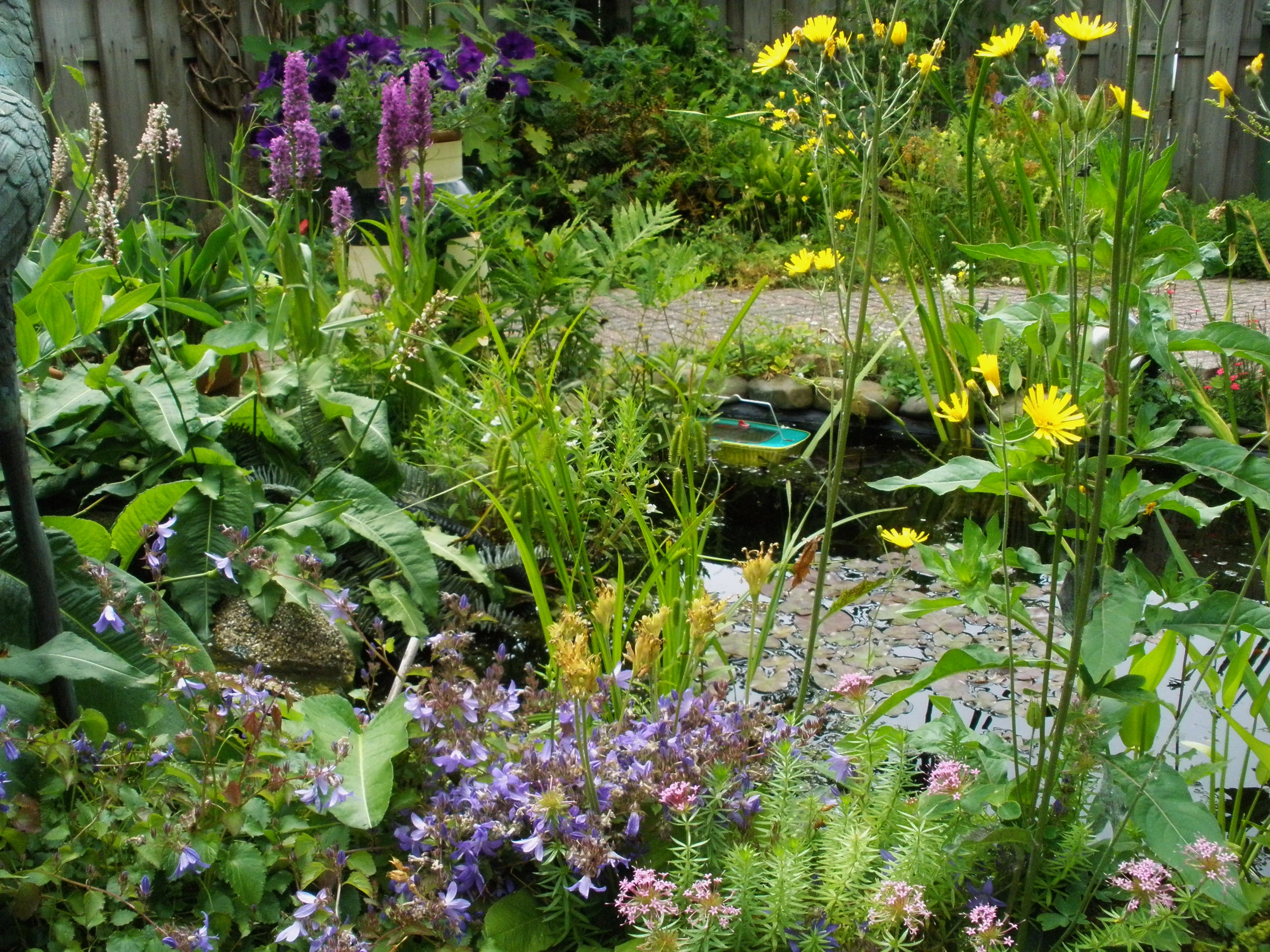 Een weelderige tuin met kleurrijke bloemen en een kleine vijver.