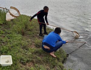 foto van twee kinderen met een schepnet bij het water