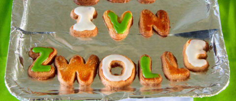 Koekjes vormen de tekst "I ❤️ N ZWOLLE" op een met folie beklede bakplaat.