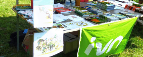 Informatietafel met folders en brochures van IVN in een groene buitenomgeving.