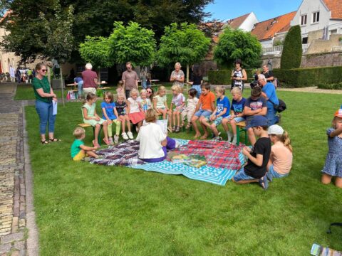 groep kinderen op kleed in kasteeltuin