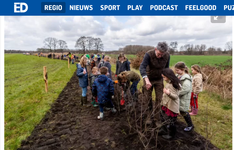 Mensen planten bomen op een modderig pad in een open veld. Kinderen kijken toe en helpen mee.