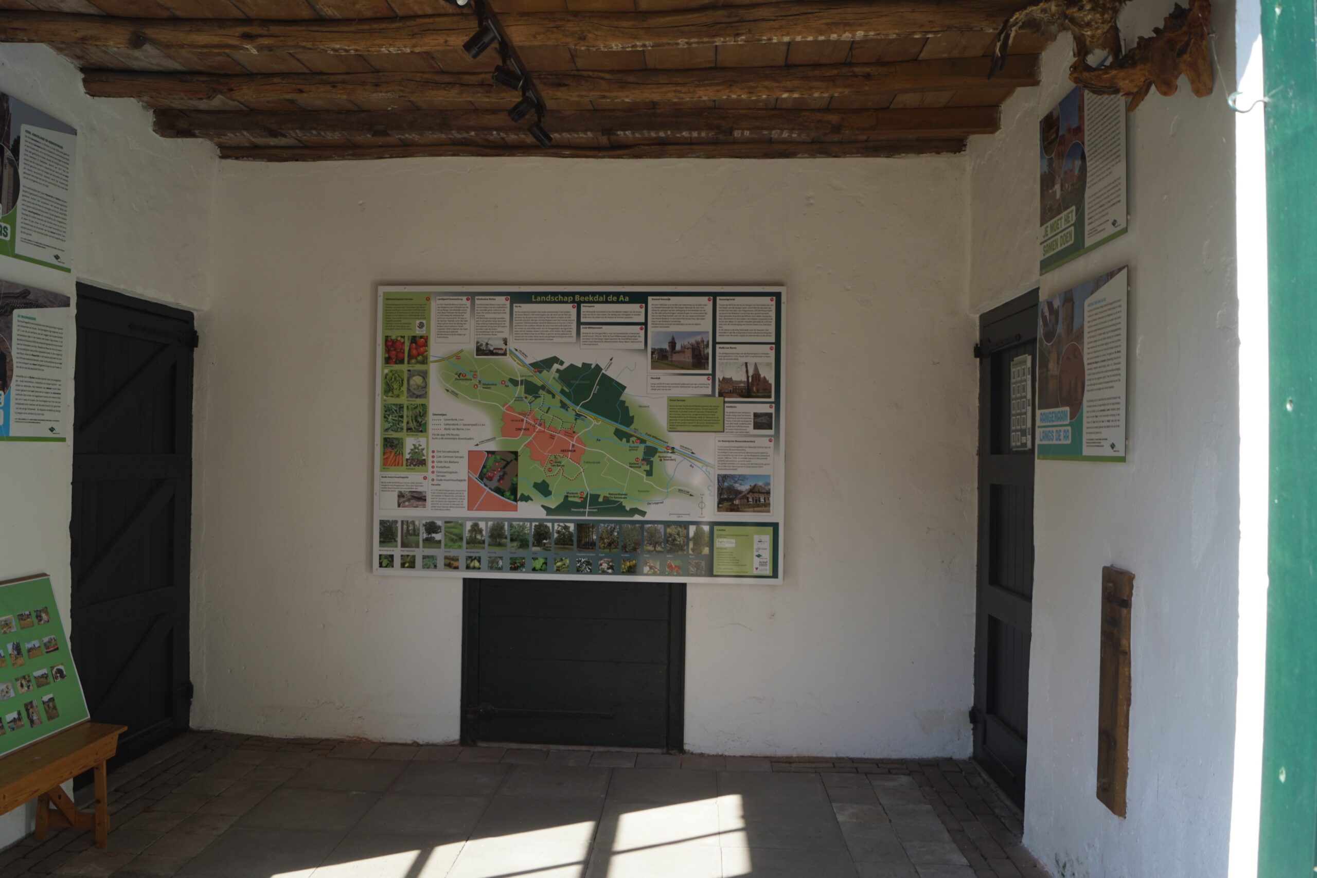 Informatiebord over landschap Beekdal de Aa in een rustieke kamer met houten plafond.