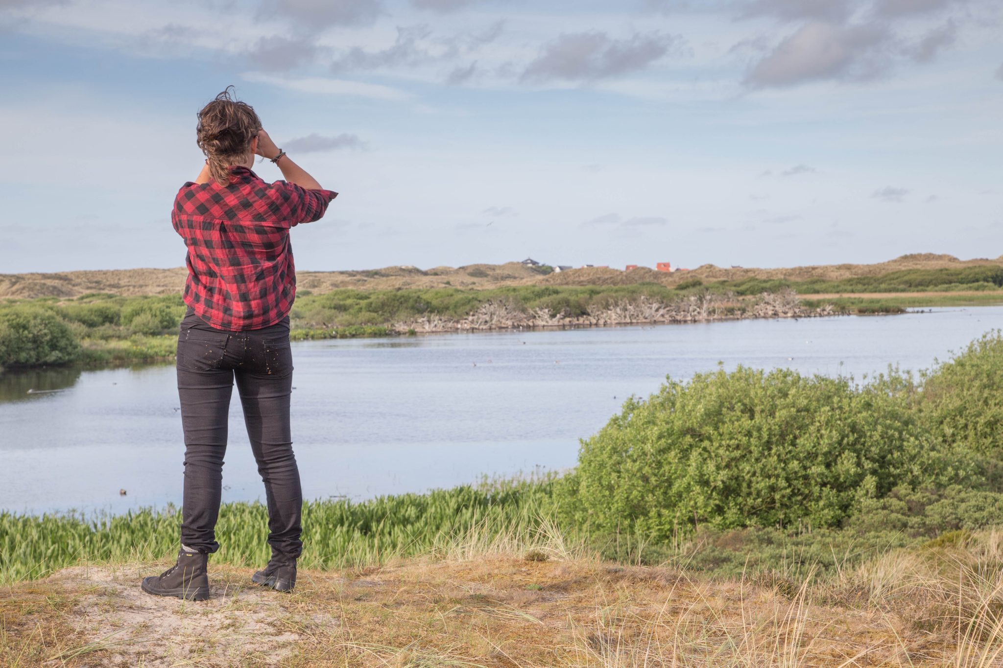 Natuurfotograaf met verderkijker in de duinen