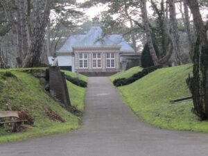 Het hoofdgebouw van de begraafplaats Bloemendaal, een statig gebouw tussen een laan van bomen
