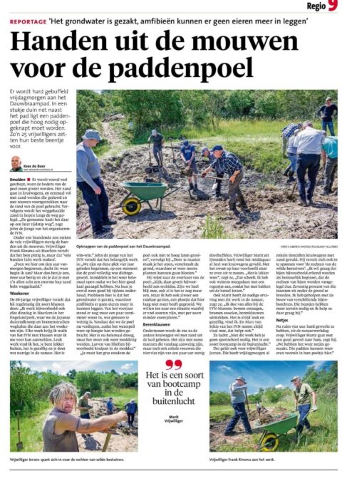 Vrijwilligers graven met scheppen bij een paddenpoel in een groene omgeving.