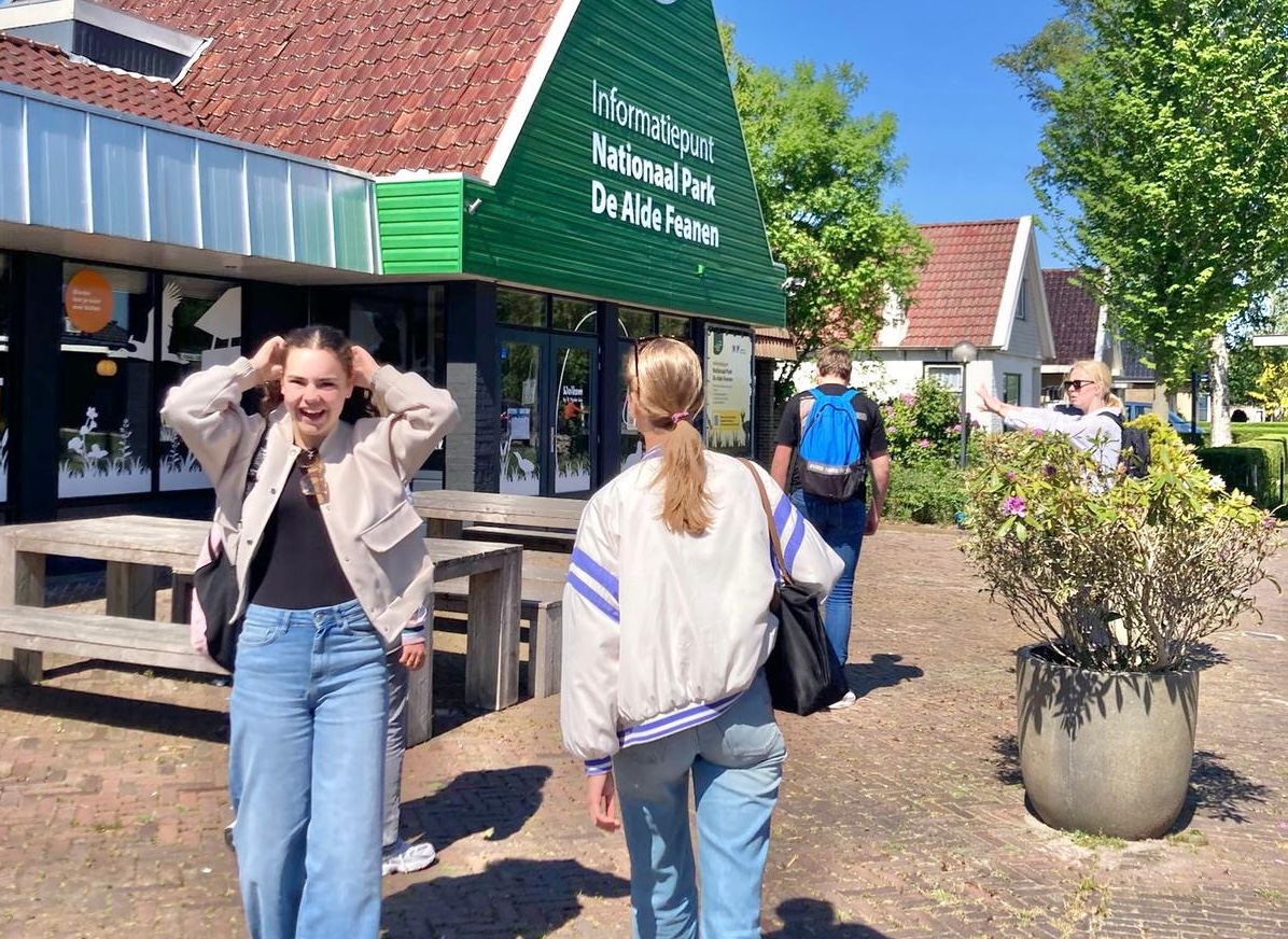 Mensen bij informatiepunt Nationaal Park De Alde Feanen op zonnige dag.