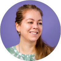 Een lachende vrouw met bruin haar voor een paarse achtergrond.