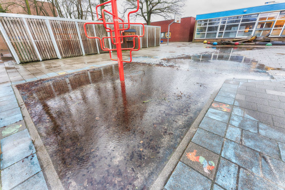 Schoolplein onder water na heftige regen 