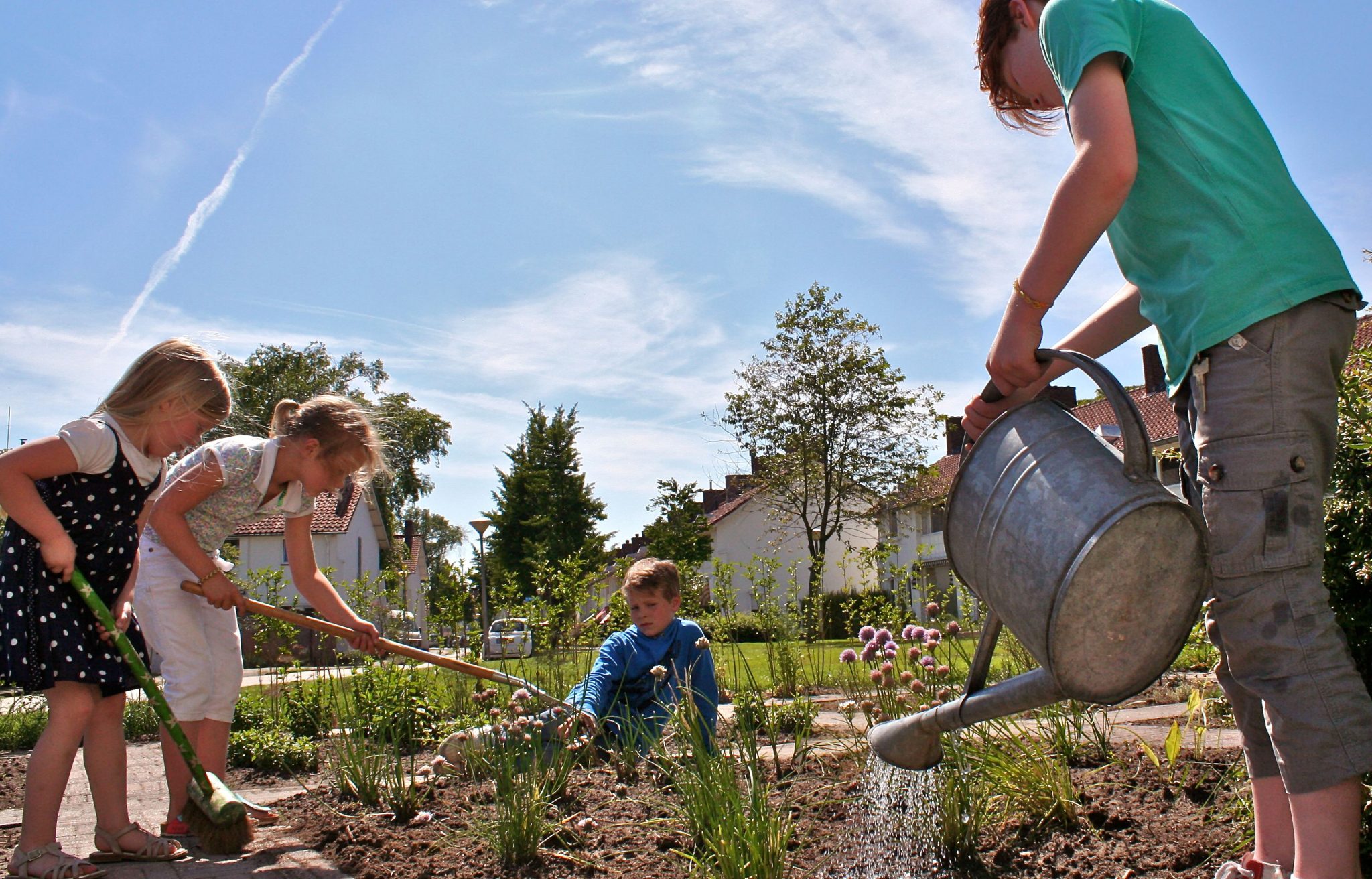 Kinderen geven planten water in buurt