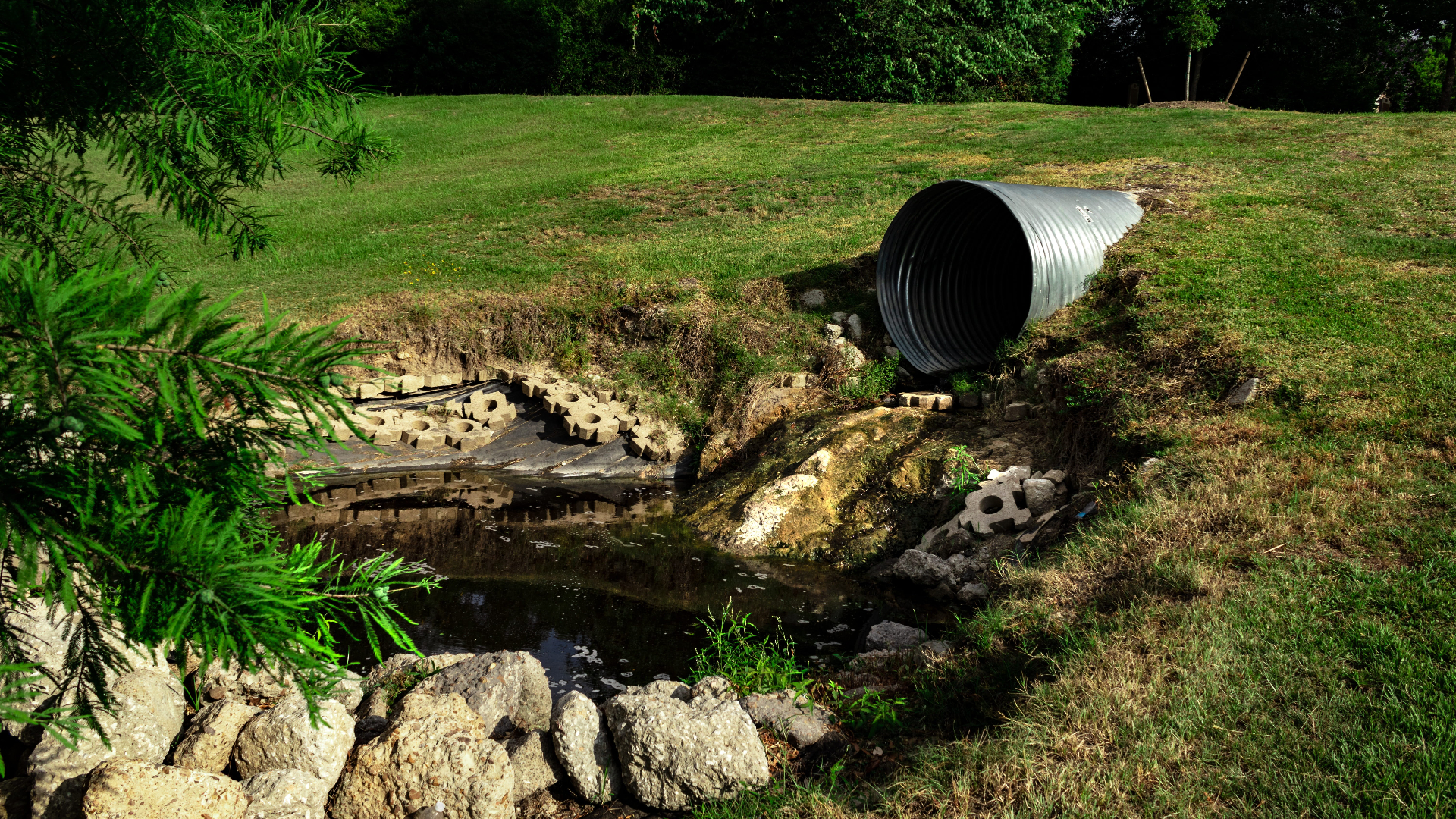 Drainagebuis bij water in weidelandschap