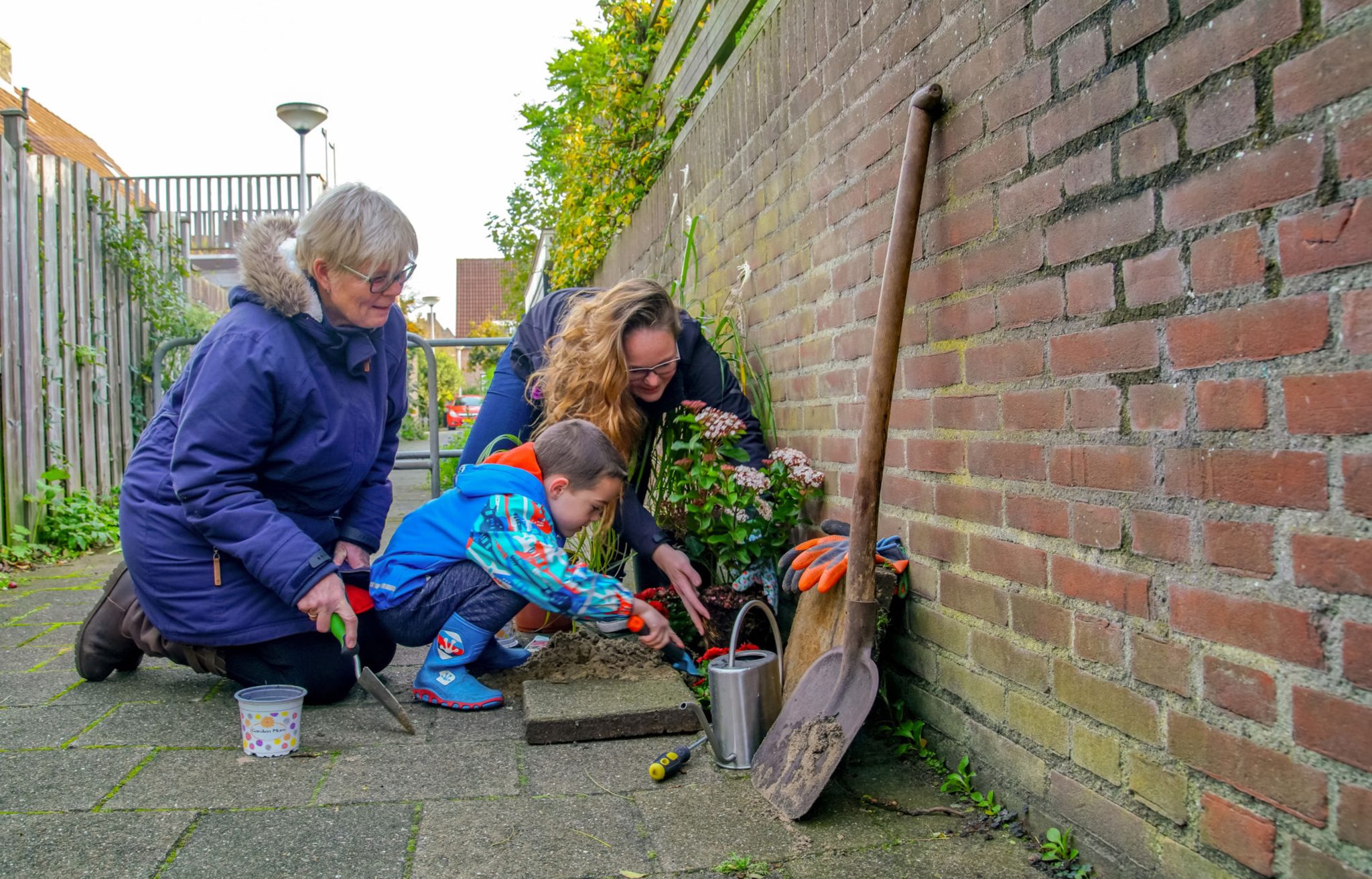 Gezin plant een geveltuintje aan.