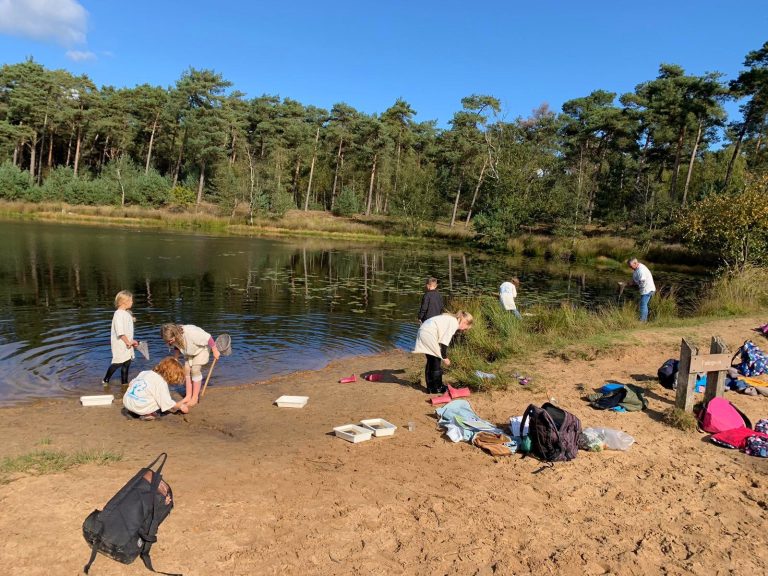 Kinderen zoeken naar waterdiertjes bij het Palingven in Het Bewaarde Land bij natuurgebied Kampina in Boxtel