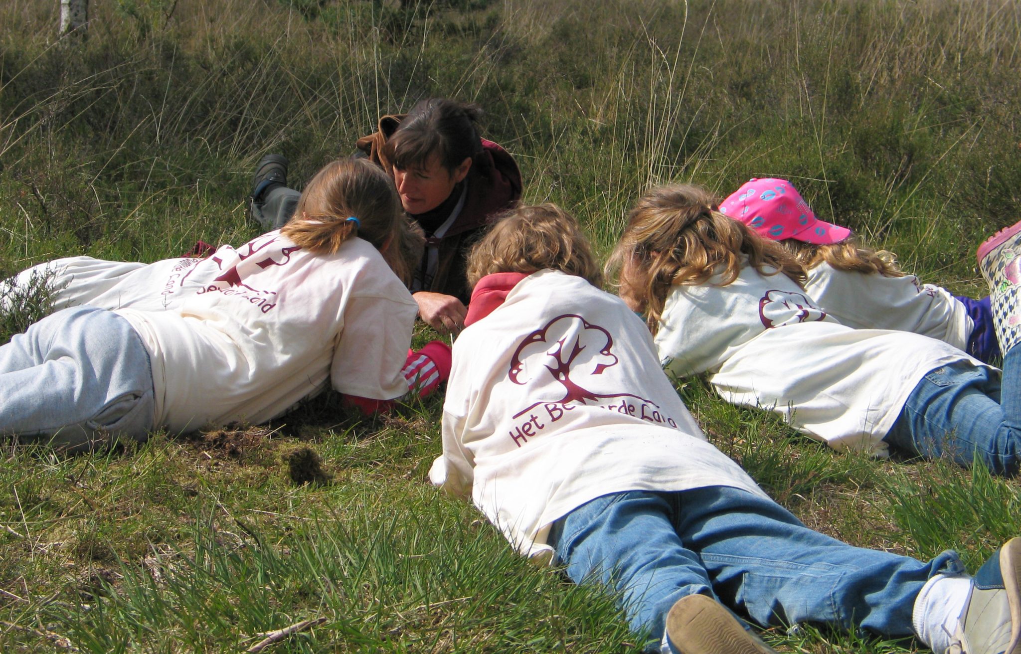 Kinderen met wachter in het gras tijdens Het Bewaarde Land