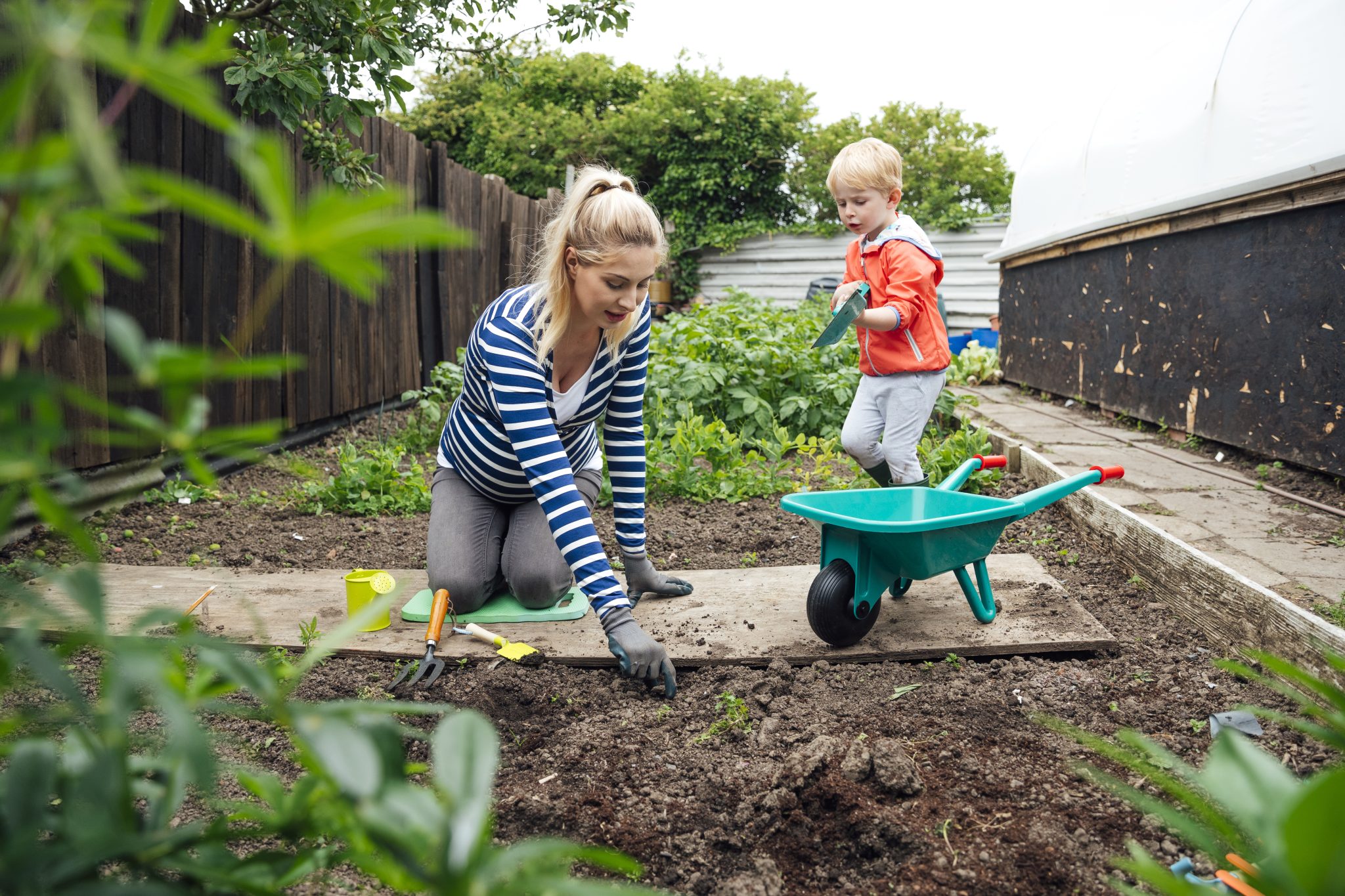 Vrouw met kind in moestuin