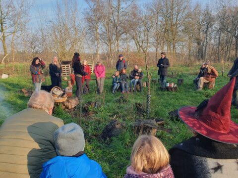 Mensen luisteren aandachtig in een kring naar een verhaal in het bos