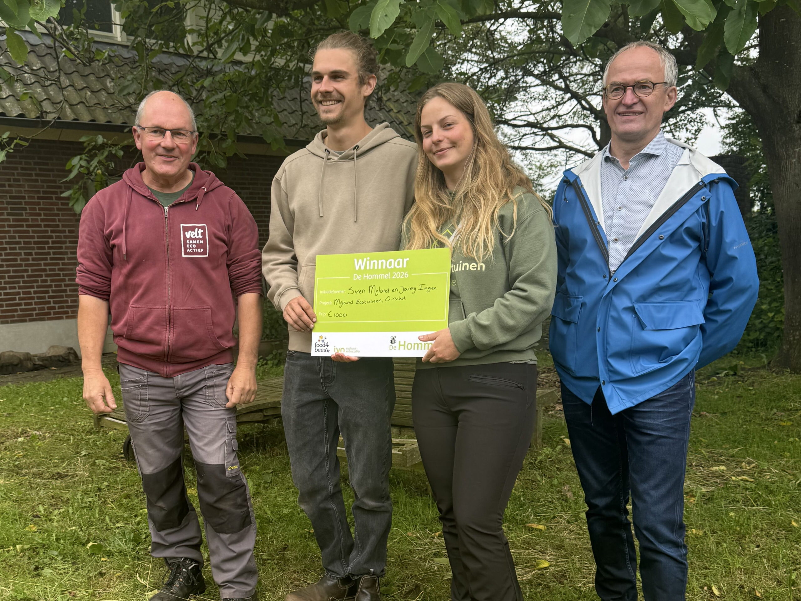Winnaars Mijland Ecotuinen neemt Hommel prijs in ontvangst.