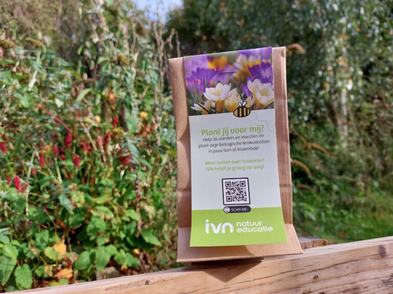 Zakje met biologische krokusbollen van IVN Natuureducatie in een natuuromgeving.
