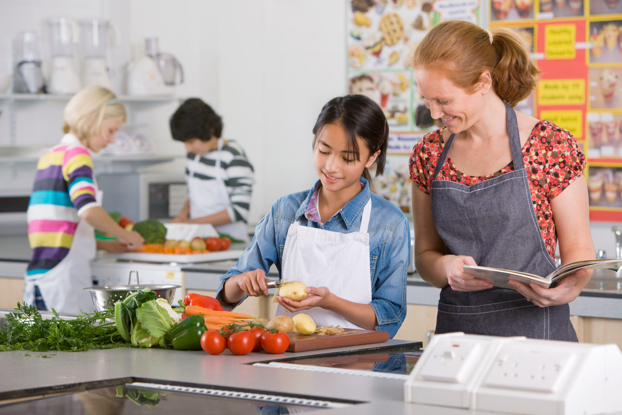 Kinderen koken samen onder toezicht van een volwassene in een keuken met verse groenten.
