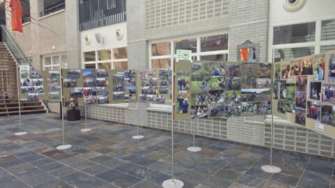 Tentoonstelling van foto's in een hal, met diverse buitenactiviteiten en educatieve momenten.