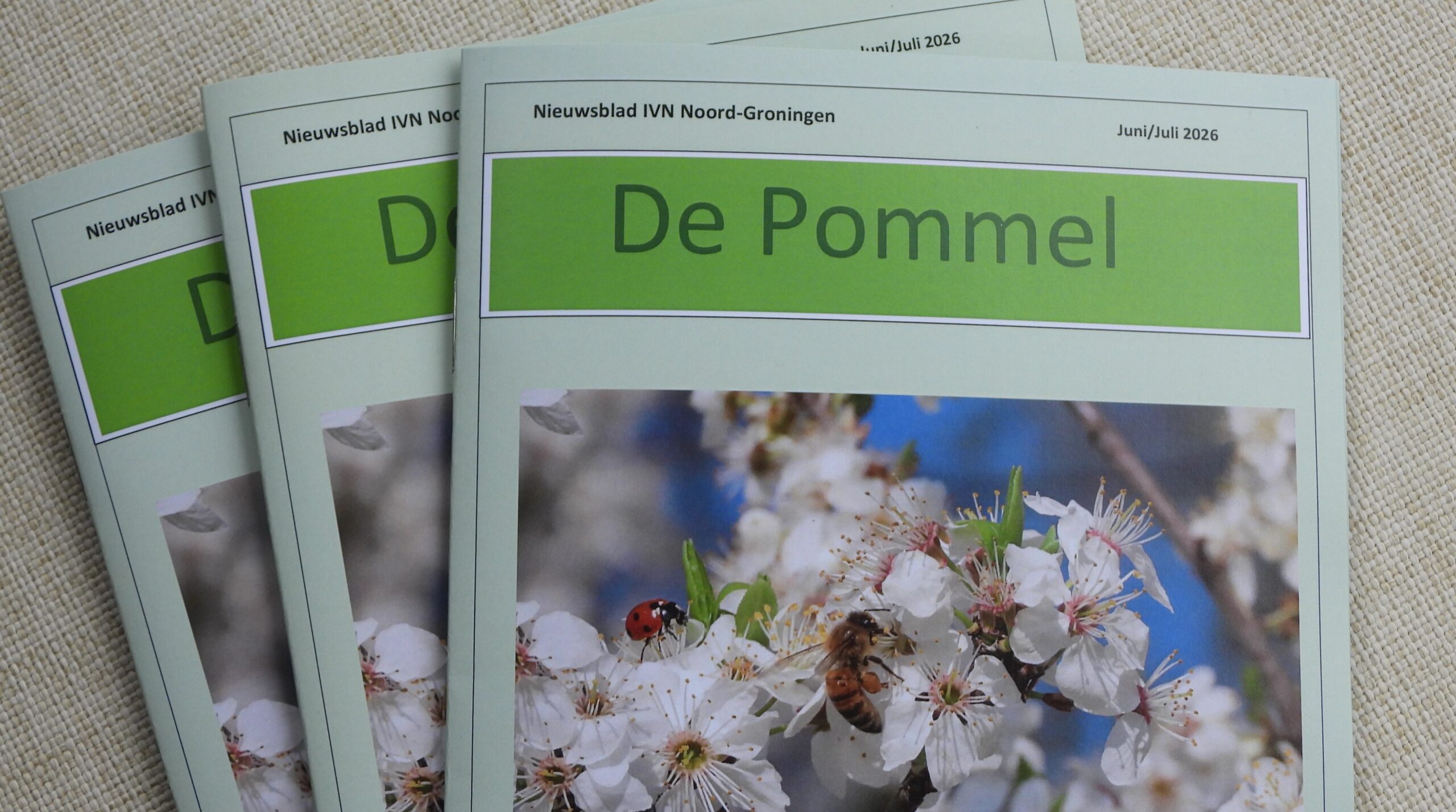 Drie tijdschriften met de titel "De Pommel" en een afbeelding van bloesem met een bij en lieveheersbeestje.