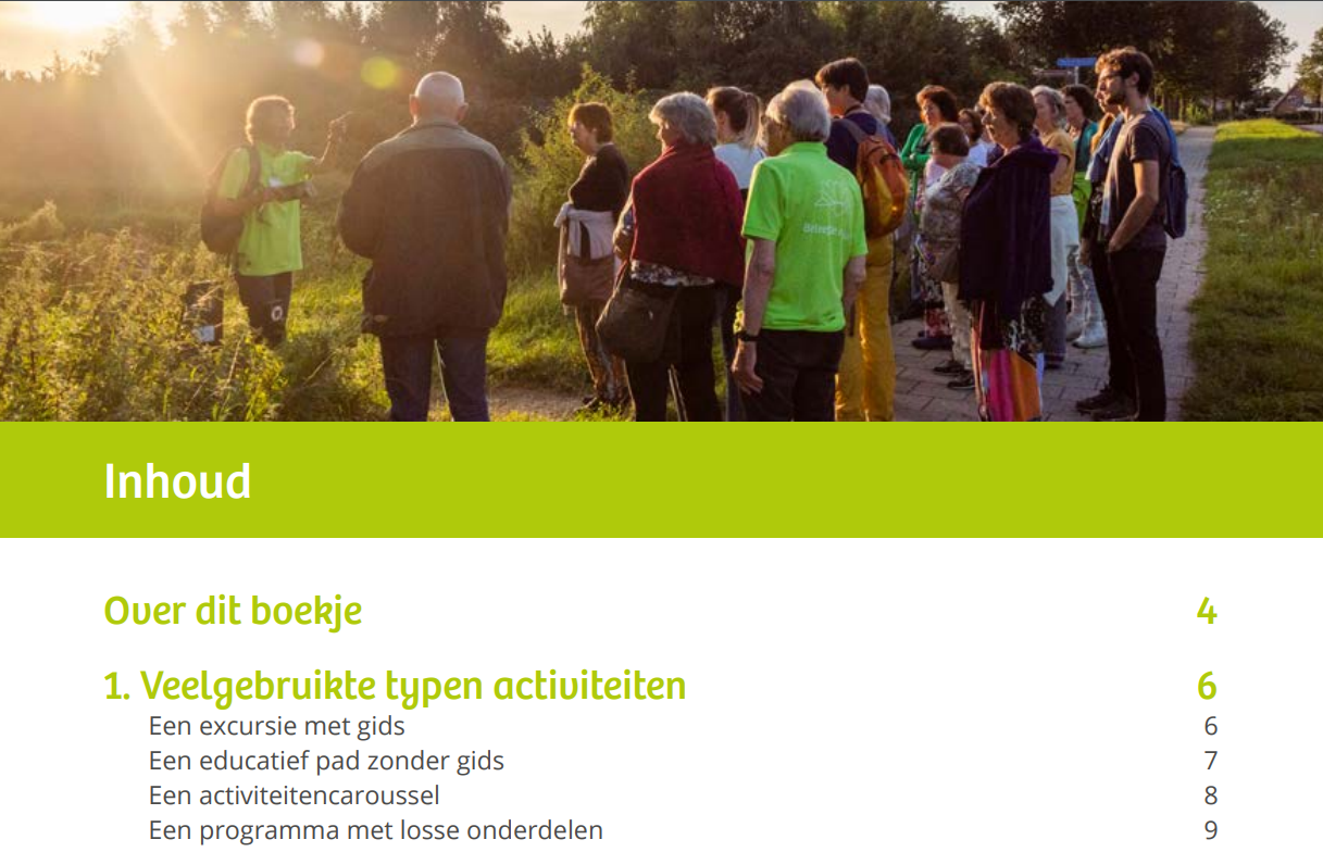 Groep mensen tijdens een excursie in natuurgebied met ondergaande zon op achtergrond.