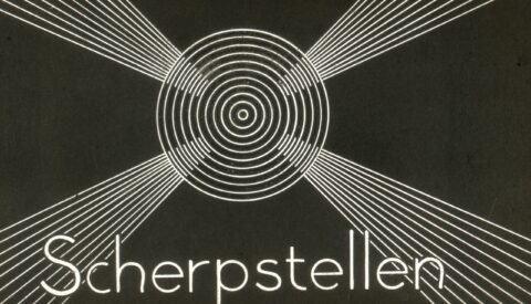 Cirkel met radiërende lijnen en het woord "Scherpstellen" eronder op een zwarte achtergrond.