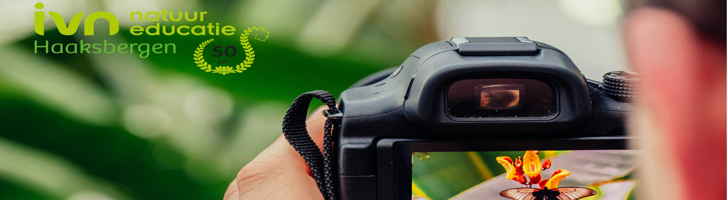 Een camera richt zich op een vlinder. Logo van IVN Haaksbergen, 50 jaar, linksboven.